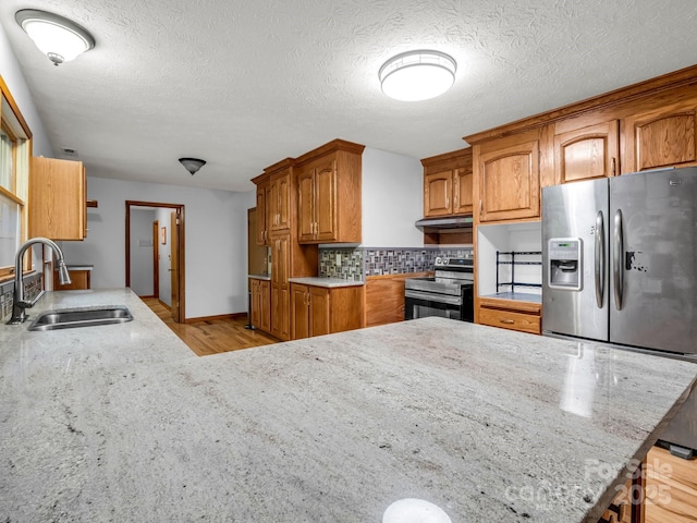 989 Mine Gap Rd, Zirconia, NC 28790 - kitchen featuring appliances with stainless steel finishes, a sink, decorative backsplash, brown cabinets, and light stone countertops