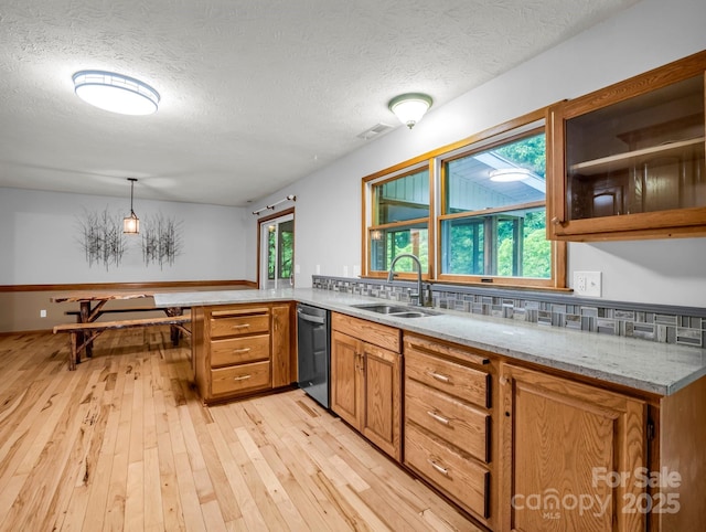 989 Mine Gap Rd, Zirconia, NC 28790 - kitchen featuring a sink, stainless steel dishwasher, light wood-style flooring, brown cabinetry, and a peninsula