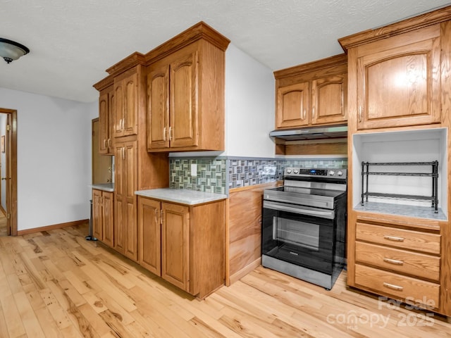 989 Mine Gap Rd, Zirconia, NC 28790 - kitchen with stainless steel range with electric stovetop, light wood-type flooring, decorative backsplash, light countertops, and a textured ceiling