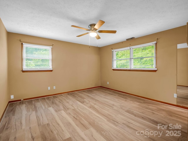 989 Mine Gap Rd, Zirconia, NC 28790 - unfurnished room with light wood-style flooring, ceiling fan, baseboards, and a textured ceiling