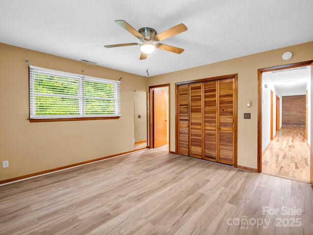 989 Mine Gap Rd, Zirconia, NC 28790 - unfurnished bedroom featuring light wood-style flooring, baseboards, a ceiling fan, and a closet