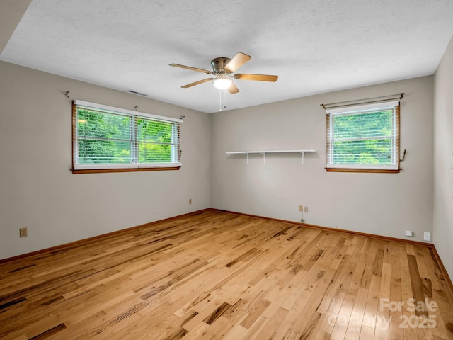 989 Mine Gap Rd, Zirconia, NC 28790 - unfurnished room with light wood finished floors, a ceiling fan, baseboards, and a textured ceiling