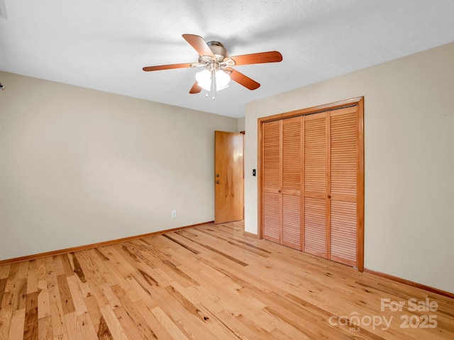 989 Mine Gap Rd, Zirconia, NC 28790 - unfurnished bedroom featuring wood finished floors, a closet, baseboards, and a ceiling fan