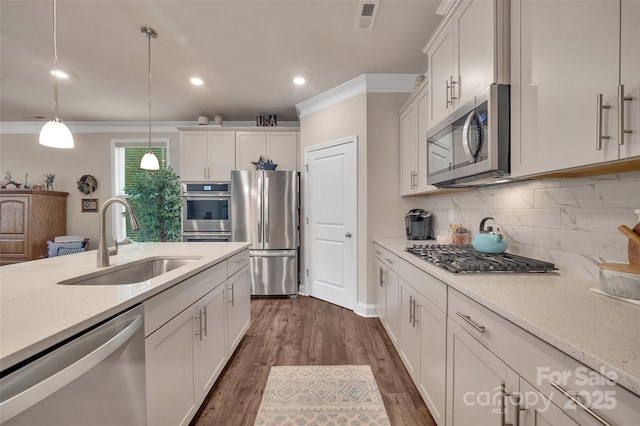 608 Latrobe Dr, Iron Station, NC 28080 - kitchen with stainless steel appliances, a sink, crown molding, backsplash, and recessed lighting
