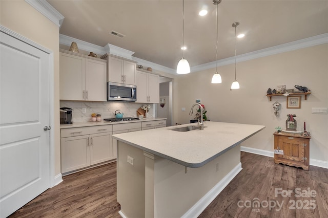 608 Latrobe Dr, Iron Station, NC 28080 - kitchen with a sink, stainless steel appliances, ornamental molding, dark wood-type flooring, and an island with sink