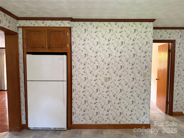 6018 Unionville Rd, Monroe, NC 28110 - kitchen featuring freestanding refrigerator, wallpapered walls, ornamental molding, and baseboards