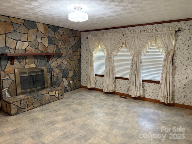 6018 Unionville Rd, Monroe, NC 28110 - unfurnished living room with wallpapered walls, a stone fireplace, baseboards, heating unit, and a textured ceiling