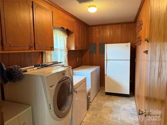 6018 Unionville Rd, Monroe, NC 28110 - laundry room with cabinet space, wood walls, washer and dryer, a textured ceiling, and electric panel
