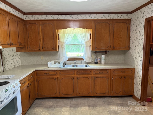 6018 Unionville Rd, Monroe, NC 28110 - kitchen featuring a sink, wallpapered walls, electric range, brown cabinets, and crown molding