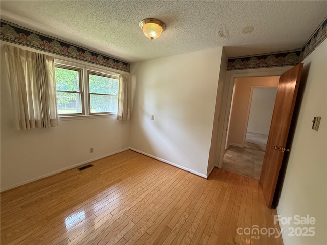 6018 Unionville Rd, Monroe, NC 28110 - spare room featuring light wood-style floors, a textured ceiling, and baseboards