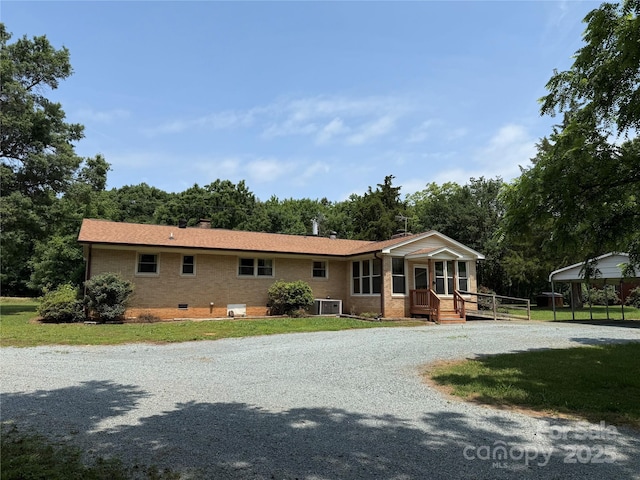 6018 Unionville Rd, Monroe, NC 28110 - single story home featuring central AC unit, brick siding, a front lawn, gravel driveway, and a chimney