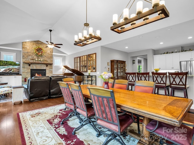 26 Balsam High Rd, Biltmore Lake, NC 28715 - dining area with a ceiling fan, wood-type flooring, a stone fireplace, vaulted ceiling, and a chandelier