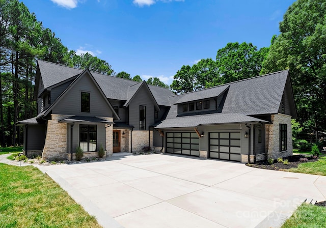 20000 Schooner Dr, Cornelius, NC 28031 - view of front of home with stone siding, driveway, a shingled roof, and a garage