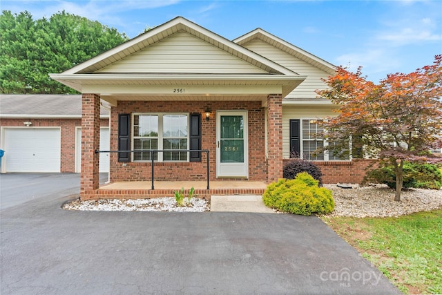 2561 26th Ave NE, Hickory, NC 28601 - view of front of home with covered porch, brick siding, an attached garage, and asphalt driveway