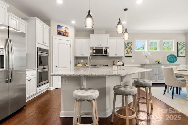 1467 Tranquility Blvd, Lancaster, SC 29720 - kitchen featuring appliances with stainless steel finishes, tasteful backsplash, white cabinets, a kitchen breakfast bar, and dark wood-style flooring