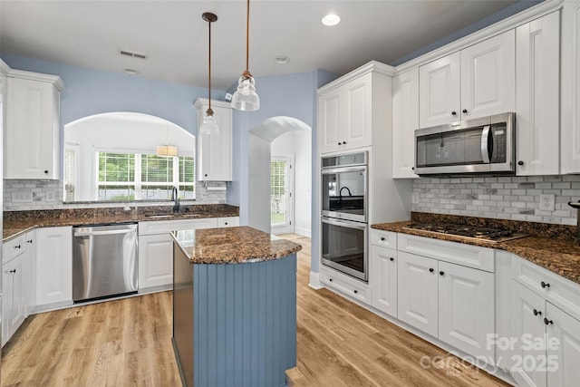 1009 Jerry Ln, Matthews, NC 28105 - kitchen featuring appliances with stainless steel finishes, a sink, arched walkways, white cabinets, and recessed lighting