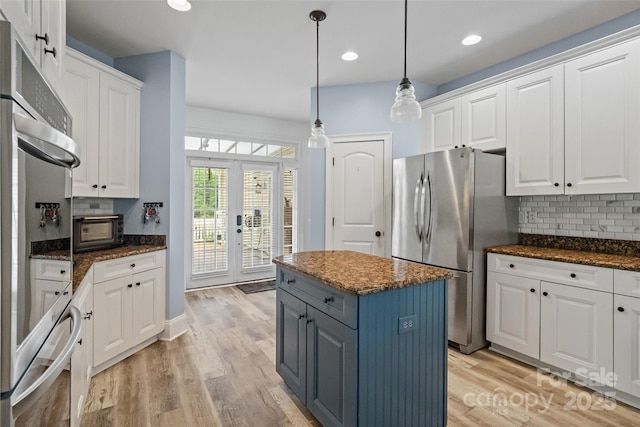 1009 Jerry Ln, Matthews, NC 28105 - kitchen with appliances with stainless steel finishes, white cabinetry, a center island, backsplash, and light wood finished floors