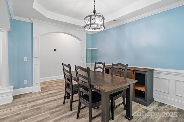 1009 Jerry Ln, Matthews, NC 28105 - dining area featuring a raised ceiling, arched walkways, a chandelier, light wood finished floors, and ornamental molding