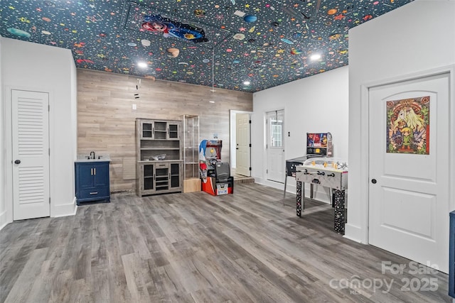 1009 Jerry Ln, Matthews, NC 28105 - recreation room featuring wood finished floors, an accent wall, baseboards, and a sink