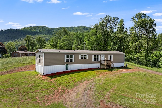 410 Fork Mountain Rd, Bakersville, NC 28705 - manufactured / mobile home with a forest view, a front yard, and driveway