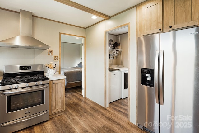 410 Fork Mountain Rd, Bakersville, NC 28705 - kitchen with stainless steel appliances, wall chimney exhaust hood, washing machine and clothes dryer, crown molding, and dark wood finished floors