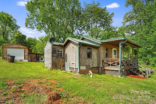 410 Fork Mountain Rd, Bakersville, NC 28705 - view of front of home featuring a garage, a front lawn, metal roof, an outdoor structure, and covered porch