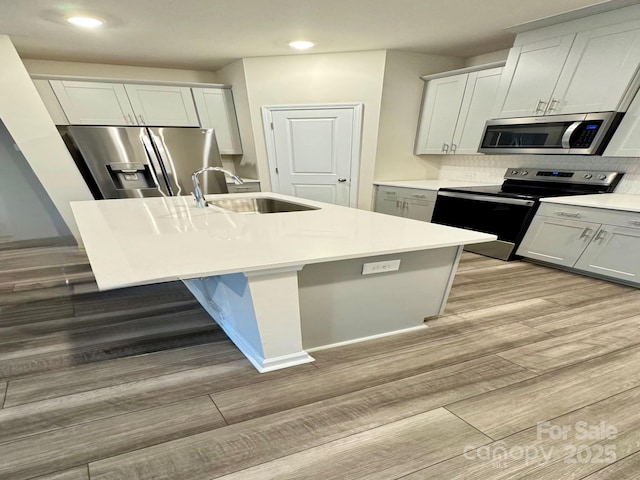 1510 Old Rivers Rd Unit 171, Concord, NC 28027 - kitchen featuring stainless steel appliances, recessed lighting, light wood-type flooring, a center island with sink, and light countertops