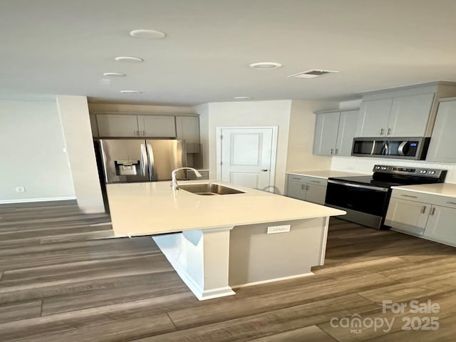 1510 Old Rivers Rd Unit 171, Concord, NC 28027 - kitchen featuring appliances with stainless steel finishes, dark wood-style floors, an island with sink, and light countertops