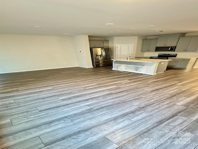 1510 Old Rivers Rd Unit 171, Concord, NC 28027 - kitchen with stainless steel appliances, gray cabinets, wood finished floors, and a center island with sink