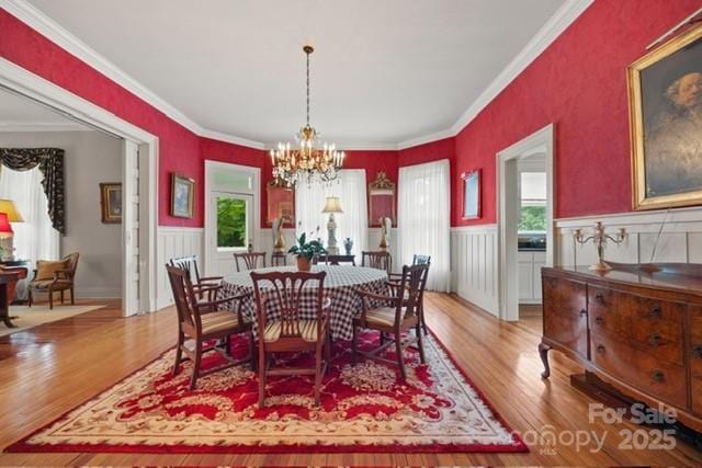 530 E Rutledge Ave, Gaffney, SC 29340 - dining area featuring plenty of natural light, a chandelier, light wood-style floors, a wainscoted wall, and crown molding