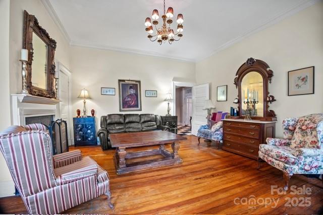 530 E Rutledge Ave, Gaffney, SC 29340 - living area with ornamental molding, a chandelier, wood finished floors, and a fireplace