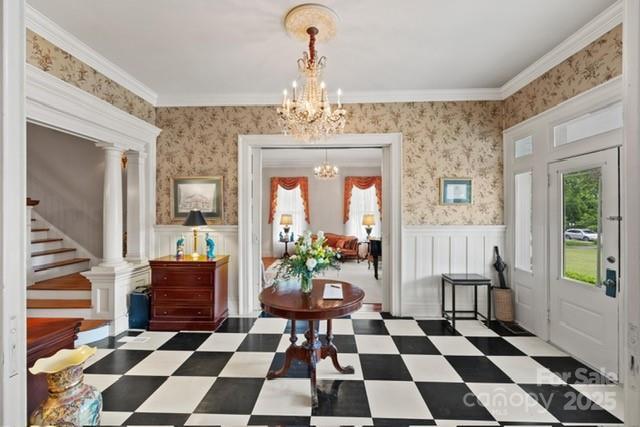 530 E Rutledge Ave, Gaffney, SC 29340 - foyer featuring healthy amount of natural light, a chandelier, wainscoting, stairway, and ornamental molding