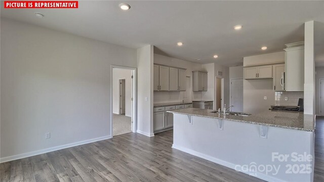 8036 Kennesaw Dr, Gastonia, NC 28056 - kitchen with a sink, a peninsula, a kitchen breakfast bar, gray cabinetry, and light stone counters