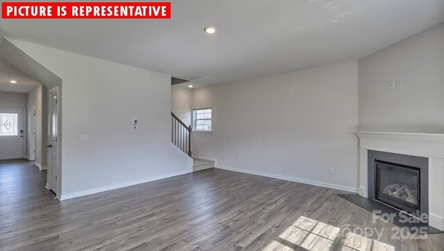 8036 Kennesaw Dr, Gastonia, NC 28056 - unfurnished living room with dark wood-style floors, stairway, a glass covered fireplace, recessed lighting, and baseboards