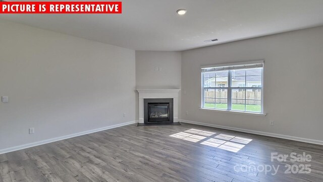 8036 Kennesaw Dr, Gastonia, NC 28056 - unfurnished living room featuring wood finished floors, a glass covered fireplace, baseboards, and recessed lighting
