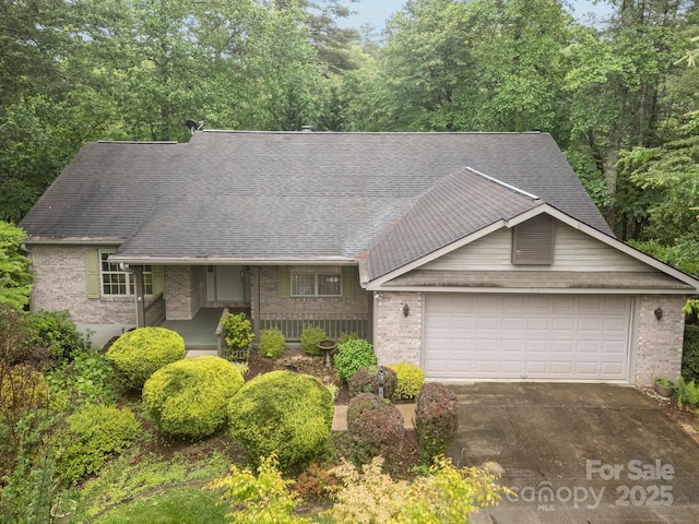 206 Pine Knot Trl, Hendersonville, NC 28739 - view of front of house with brick siding, an attached garage, driveway, and a shingled roof