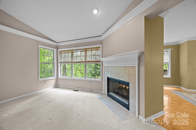 206 Pine Knot Trl, Hendersonville, NC 28739 - unfurnished living room featuring a tiled fireplace, baseboards, a textured ceiling, vaulted ceiling, and ornamental molding