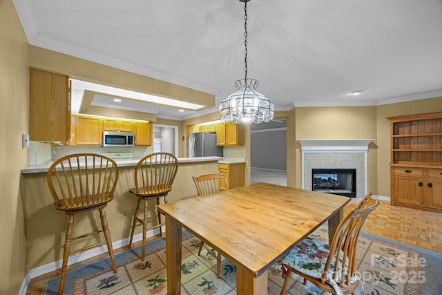 206 Pine Knot Trl, Hendersonville, NC 28739 - dining space with crown molding, a tile fireplace, baseboards, a chandelier, and recessed lighting