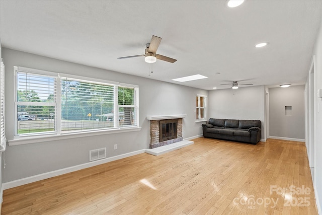 1810 13th Ave NE, Hickory, NC 28601 - living area featuring ceiling fan, a stone fireplace, a skylight, wood finished floors, and recessed lighting