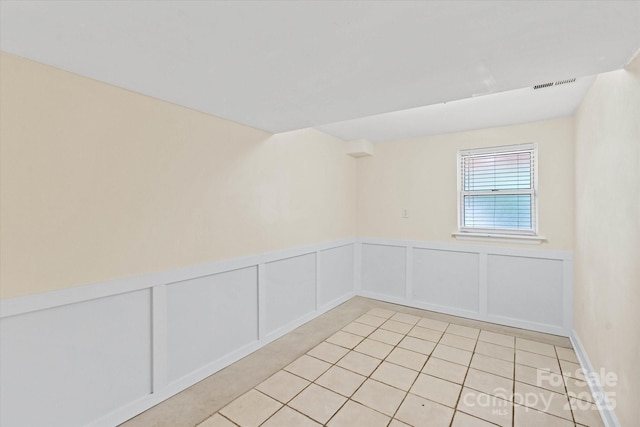 1810 13th Ave NE, Hickory, NC 28601 - spare room featuring light tile patterned floors, wainscoting, and a decorative wall