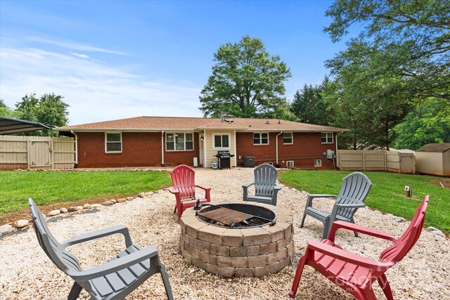 1810 13th Ave NE, Hickory, NC 28601 - rear view of house featuring an outdoor fire pit, brick siding, a gate, and a storage unit