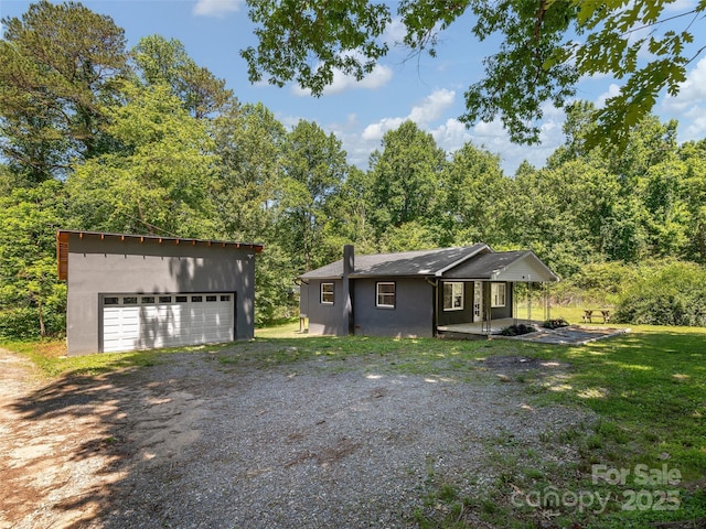 15 Burtiller Ln, Fletcher, NC 28732 - view of front of house with an outdoor structure, a chimney, a detached garage, and dirt driveway