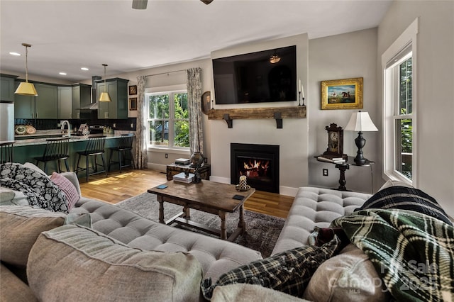109 Druid Dr, Asheville, NC 28806 - living room featuring light wood-style flooring, recessed lighting, a warm lit fireplace, baseboards, and ceiling fan