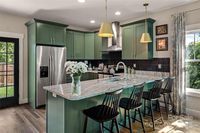 109 Druid Dr, Asheville, NC 28806 - kitchen with green cabinetry, stainless steel refrigerator with ice dispenser, wall chimney exhaust hood, a peninsula, and light stone countertops