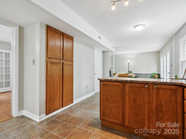 7317 Red Branch Ln, Charlotte, NC 28226 - kitchen with brown cabinets, baseboards, and dark tile patterned floors