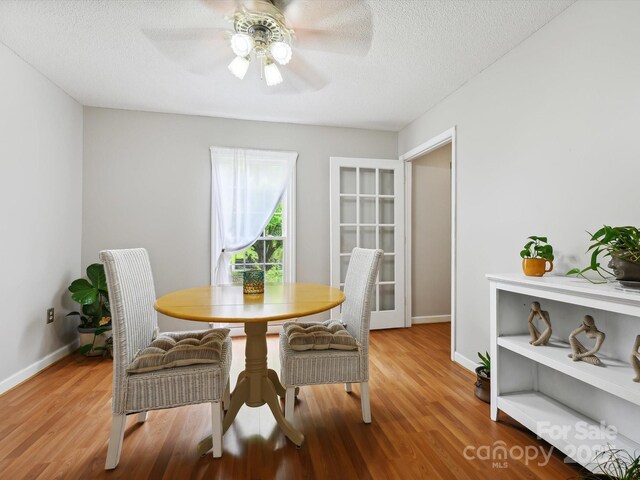 7317 Red Branch Ln, Charlotte, NC 28226 - dining room featuring wood finished floors, a ceiling fan, a textured ceiling, and baseboards