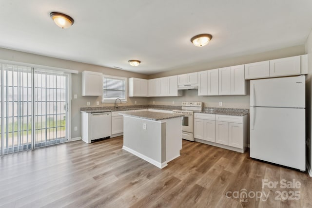 673 Shellbark Dr, Concord, NC 28025 - kitchen with white appliances, white cabinets, under cabinet range hood, light wood-style floors, and a center island