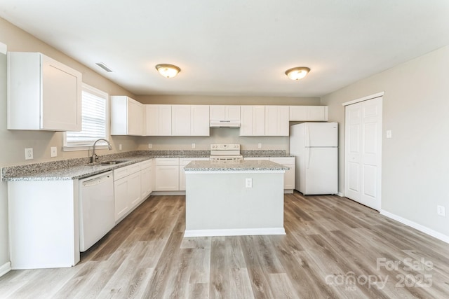 673 Shellbark Dr, Concord, NC 28025 - kitchen featuring white appliances, a sink, under cabinet range hood, light wood-style flooring, and a center island