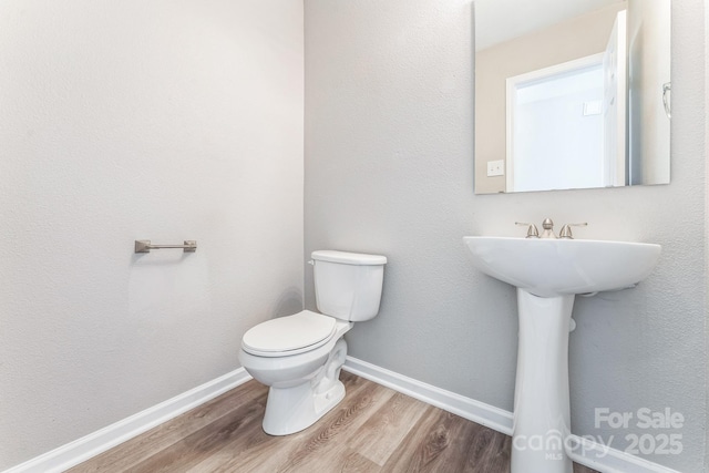 673 Shellbark Dr, Concord, NC 28025 - half bathroom with wood finished floors, toilet, and baseboards