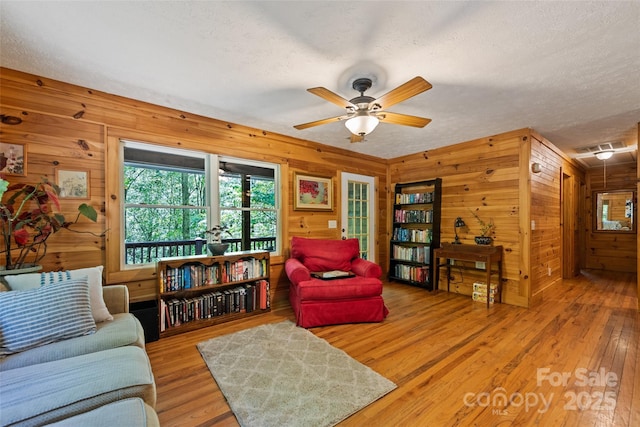 823 Turtle Creek Rd, Sylva, NC 28779 - sitting room with healthy amount of natural light, wood walls, a textured ceiling, hardwood / wood-style floors, and a ceiling fan